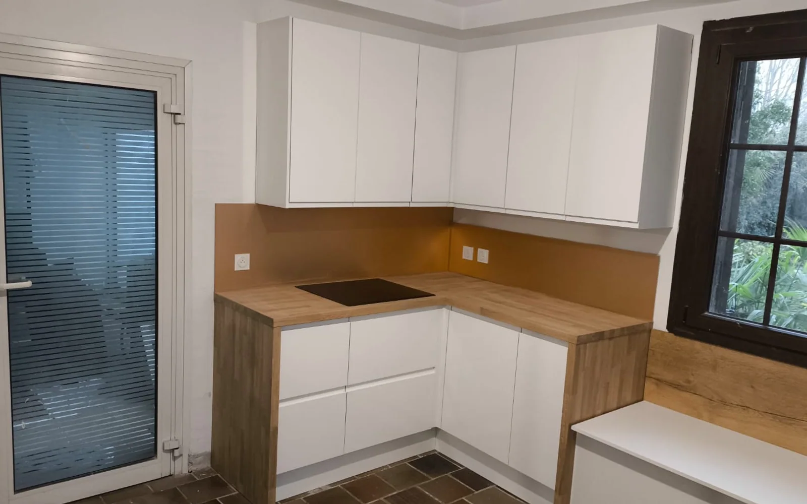 Cuisine blanche et bois après rénovation vue depuis la porte